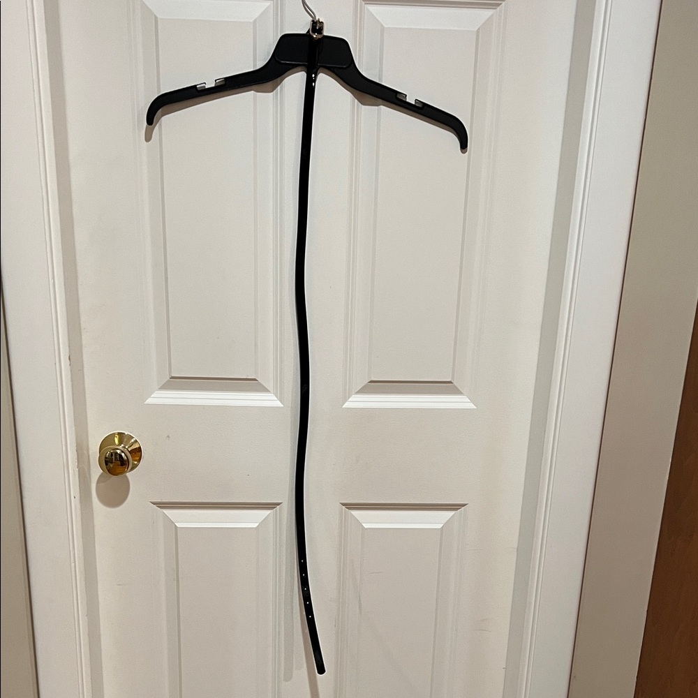Woman’s, shiny, black belt with gold colored buckle and 5 adjustable holes.